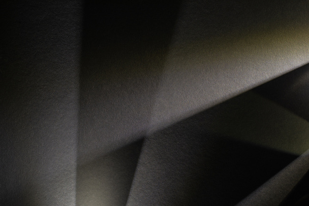 helles Prisma mit Strahlen auf dunkel strukturiertem Hintergrund - Foto, Bild