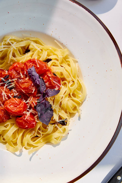 丸い皿にトマトの美味しいパスタの上面図 - 写真・画像