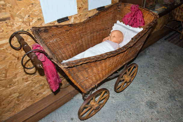 Vista de cerca de la cuna del bebé viejo. Cuna tradicional con juguete de bebé en la habitación. Cuna vieja sobre ruedas
 - Foto, imagen