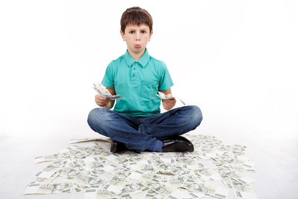 boy sitting on money, money concept - Zdjęcie, obraz
