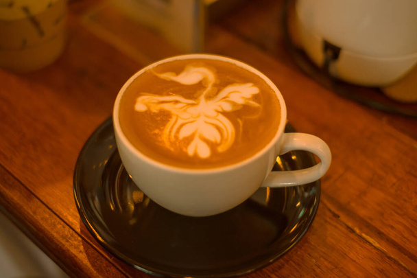 En üstte bir fincan sütlü kahve ve sıcak bir ton kahve. - Fotoğraf, Görsel