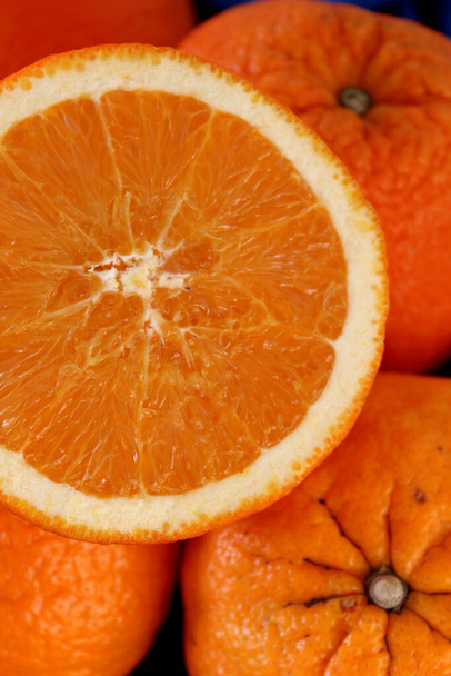 Sappige sinaasappels op een tafel. Donkergrijze achtergrond met kopieerruimte. Zomervruchten close-up foto.  - Foto, afbeelding