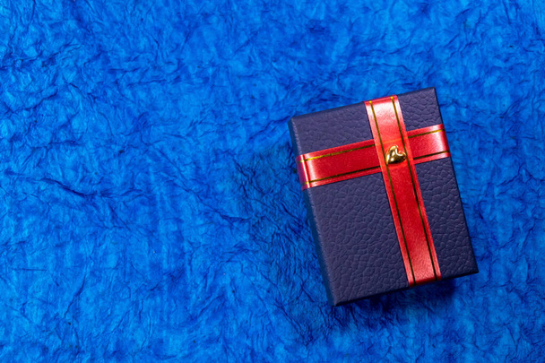 Вид сверху голубой подарочной коробки с красной лентой. Концепция Валентина
. - Фото, изображение