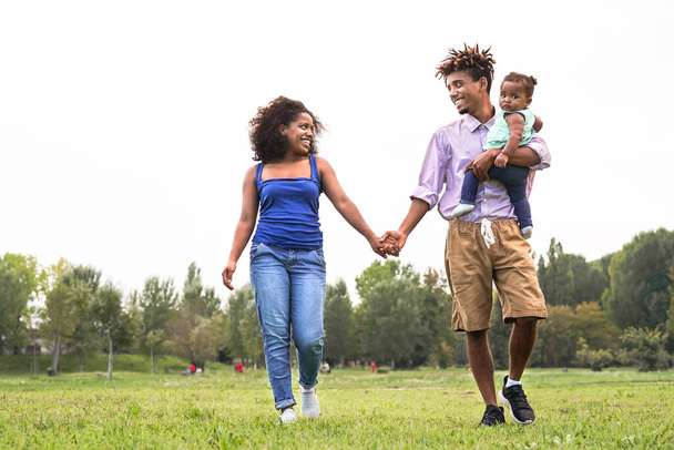 公園で楽しいアフリカの家族-週末の屋外で一緒に時間を楽しむ母親と父親-両親の愛と母の日の概念 - 写真・画像