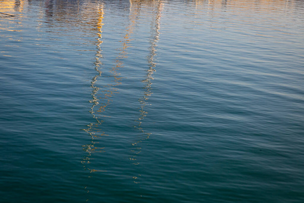 Reflexões de barcos no porto sobre a água do mar
 - Foto, Imagem