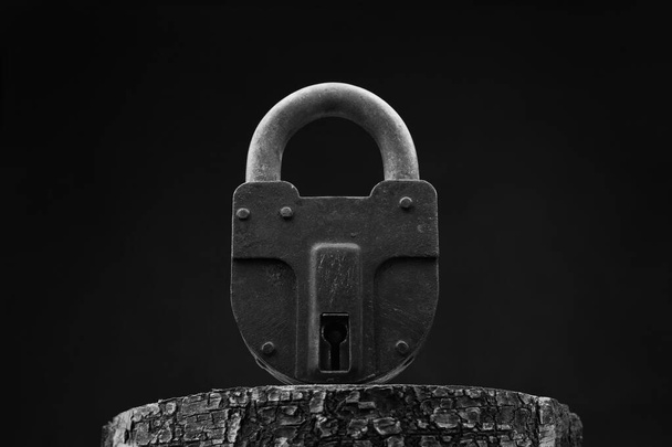 大きな古い南京錠を閉じる-黒の背景にアップ。白黒写真 - 写真・画像