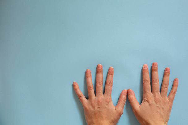 Handkennzeichnung. Hygiene während einer Epidemie. Weibliche Hände auf blauem Hintergrund.  - Foto, Bild