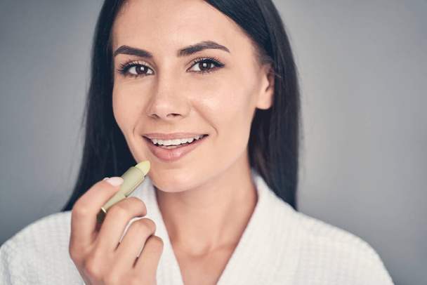 Female holding a cosmetic product in her hand - Foto, immagini