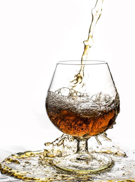 Glass with splashes from whisky on a black background - Фото, зображення