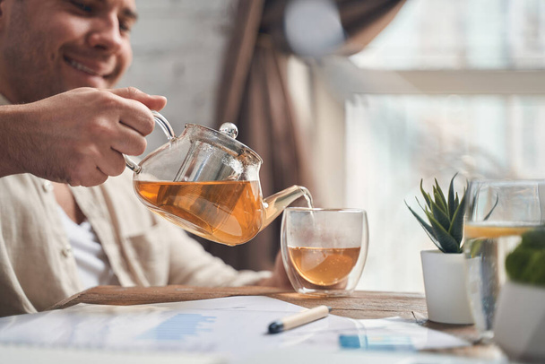 Man filling a mug with a herbal drink - 写真・画像
