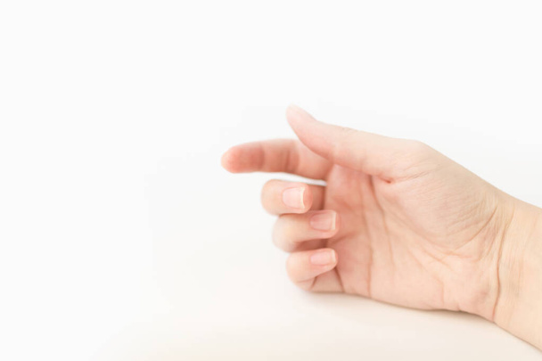 Fermer femme main avec des ongles forme de carré doux tient quelque chose dans les doigts. Femme garde l'objet virtuel. Soins des ongles à la maison. Espace de copie
 - Photo, image