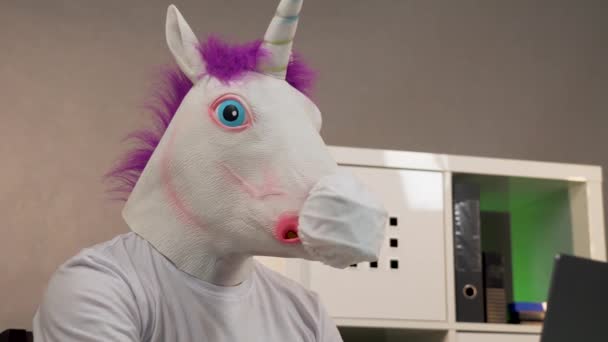 a man in a unicorn mask and a protective face mask for a laptop - Filmagem, Vídeo