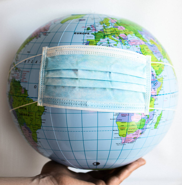 Globus mit Geld bedeckt mit Atemmaske - Covid 19 - Foto, Bild