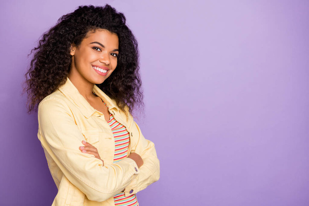 Turned photo of positive cheerful successful afro american girl cross hands enjoy work study success wear casual style clothing isolated over violet color background - 写真・画像