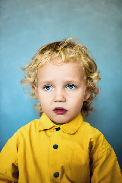 Altın saçlı ve mavi gözlü sevimli küçük çocuk. - Fotoğraf, Görsel