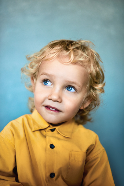 Uroczy, słodki chłopiec ze złotymi włosami i niebieskimi oczami - Zdjęcie, obraz