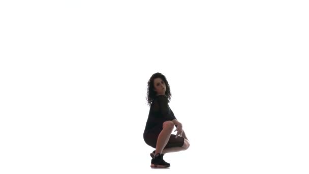 joven hermosa chica en un negro transparente apretado traje energéticamente bailando dancehall, danza de la calle, twerk sobre fondo blanco, aislado
  - Metraje, vídeo