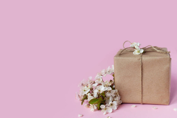 Handgemaakte geschenkdoos met kersenbloemen op achtergrond geïsoleerd op kleur - Foto, afbeelding