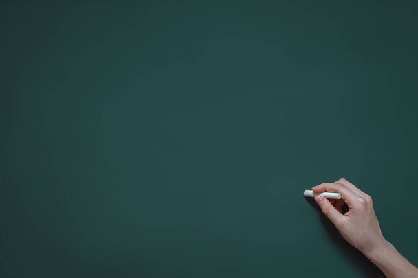hand writes in chalk on a blackboard, school class, study at school, college, new knowledge, place for text - Фото, изображение