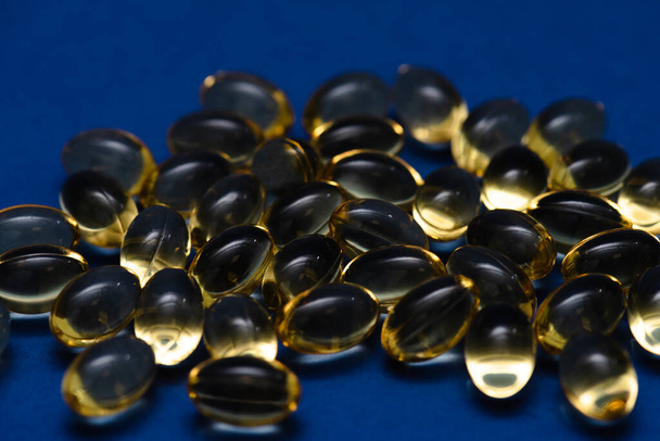 Mavi arka planda duran vitaminler. Omega Balık Yağı - Fotoğraf, Görsel