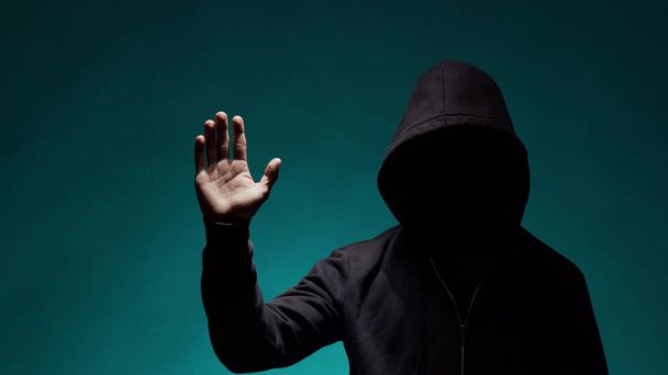 Retrato del hacker con capucha. Cara oscura y oscura. Ladrón de datos, fraude en internet, dark net y ciberseguridad
. - Foto, imagen