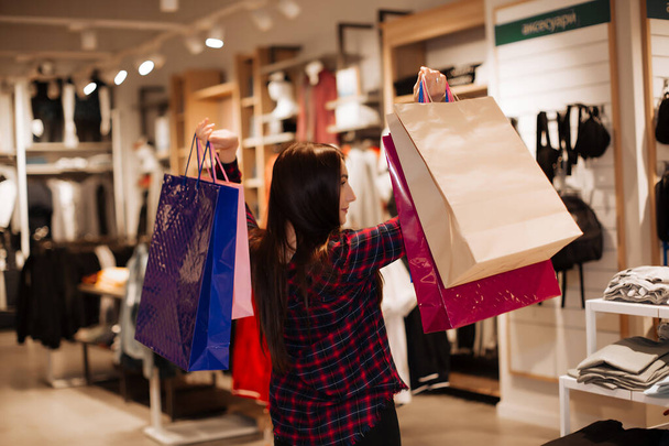 happy girl shopping in the store, hands up. - Foto, Imagen