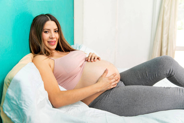 Young real pregnat woman happy in the bedroom of their house. - Foto, Imagen