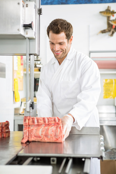 Butcher Slicing Meat On Bandsaw In Shop - Foto, imagen