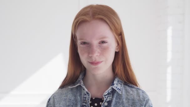 Χαρούμενο χαμογελαστό πρόσωπο της όμορφης έφηβης με φακίδες και κόκκινα μαλλιά - Πλάνα, βίντεο