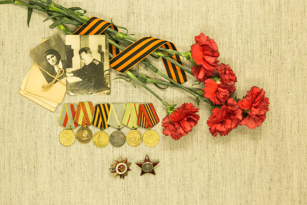 Zafer Günü. Atalarımızın başarısını hatırlıyoruz. Siparişler ve madalyalar, savaş mektupları, arka planda kırmızı karanfillerin fotoğrafları.. - Fotoğraf, Görsel