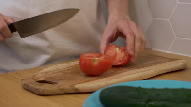 a man cuts a tomato on a chopping Board - Filmagem, Vídeo