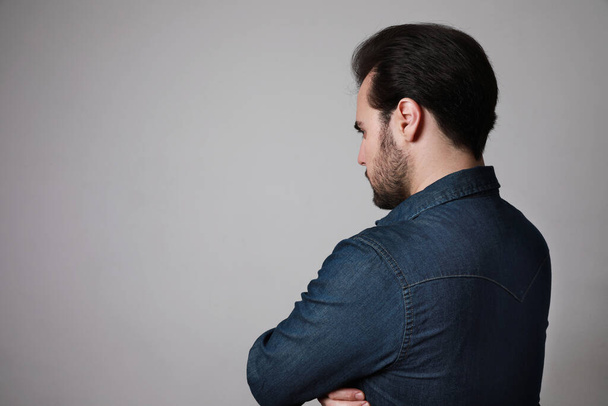 Silhouette of a European bearded man from the back in a casual shirt look to the side. Space for text. - Photo, Image