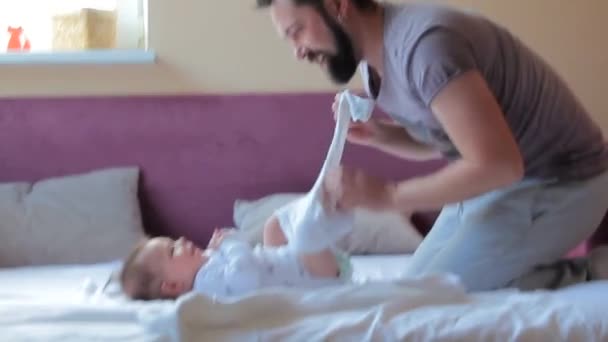 Jeune père changer la couche et les vêtements pour bébé fille à la maison
 - Séquence, vidéo