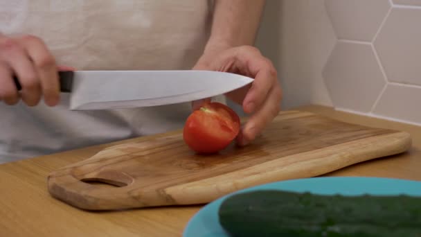 a man cuts a tomato on a chopping Board - Filmagem, Vídeo