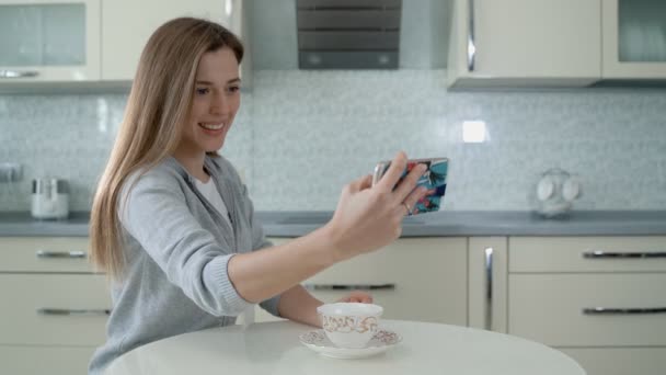Selfie mutlu insan. Sosyal medyada akıllı telefondan sörf yapan bir kadın. Pembe saçlı güzel bir kız selfie çeker ve mutfaktaki yangını fark etmez.. - Video, Çekim