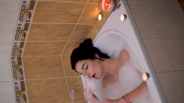 Relaxing girl in babble bath playing with foam, cozy romantic home atmosphere - Felvétel, videó