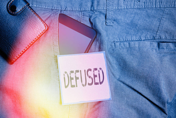 Conceptual hand writing showing Defused. Business photo showcasing make a difficult or dangerous situation calmer by reducing its cause Smartphone device inside trousers front pocket with wallet. - Photo, Image