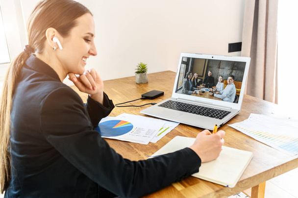 A young woman connects via video with coworkers - Zdjęcie, obraz