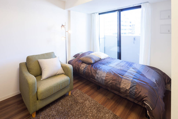 woonslaapkamer interieur in huis met voorbereid bed om te slapen - Foto, afbeelding