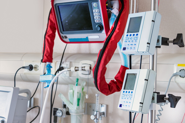 Ventilatori e monitor per segnali vitali accanto al letto dell'unità di terapia intensiva
 - Foto, immagini