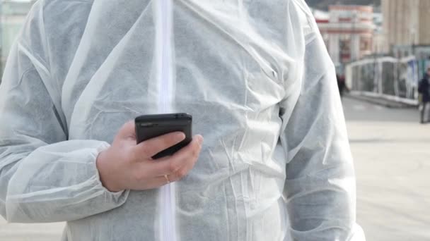 Człowiek w bieli używa smartfona - Materiał filmowy, wideo