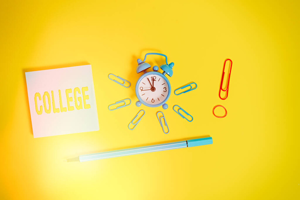 Conceptual hand writing showing College. Business photo showcasing educational institution or establishment providing higher education Alarm clock rubber band marker notepad colored background. - Photo, Image