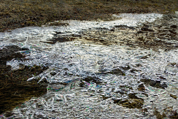 la superficie de hielo de la corriente de muelle está cubierta con residuos de vehículos de motor, enfoque selectivo
 - Foto, imagen