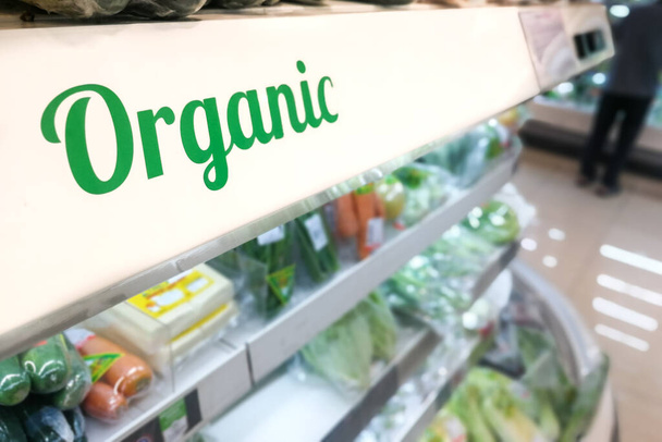 Closeup van biologische producten groenten en fruit gangpad met bewegwijzering woord in supermarkt - Foto, afbeelding