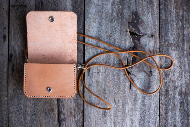 Vegetable tanned leather purse bag waist belt pocket on wood handmade bag - Photo, Image