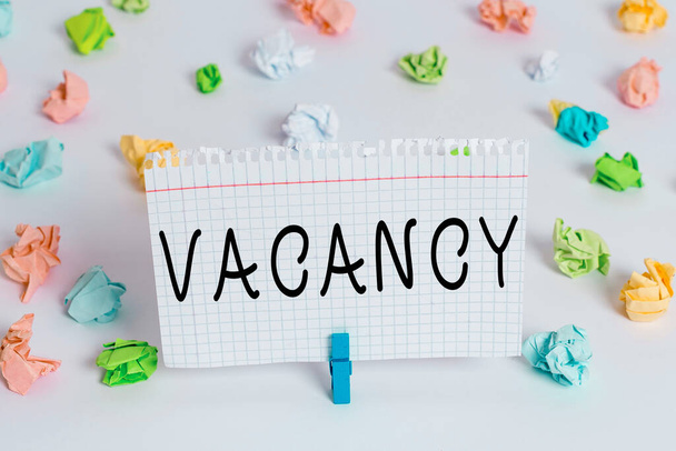 Text sign showing Vacancy. Conceptual photo available paid place in small or big company State of being vacant Colored crumpled papers empty reminder white floor background clothespin. - Photo, Image