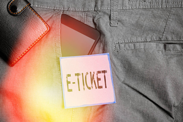 Konceptualny ręczny zapis pokazujący E Ticket. Business photo showcasing Bilet cyfrowy ważny jak bilet papierowy lub jego odpowiednik Smartphone wewnątrz kieszeni spodni przedniej z portfelem. - Zdjęcie, obraz