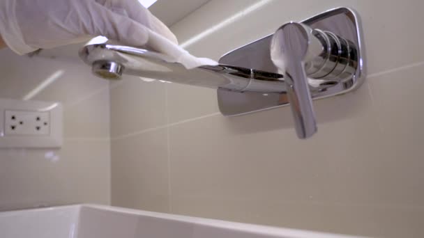 Yavaş hareket eden insan eli beyaz eldivenle banyo musluğunu siliyor, dezenfektan temizliyor, korona virüsünü önlüyor kovid 19, anti bakteri mendilleri, öldürücü mikroplar, ev bakım ürünleri, - Video, Çekim