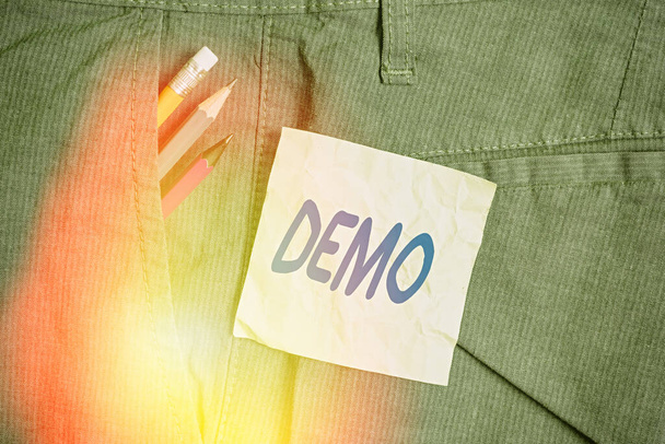 Εννοιολογική γραφή χεριών που δείχνει Demo. Επίδειξη τεχνικών και δυνατοτήτων ενός προϊόντος Δημόσια συνάντηση Writing equipment and green note paper in pocket of pants. - Φωτογραφία, εικόνα