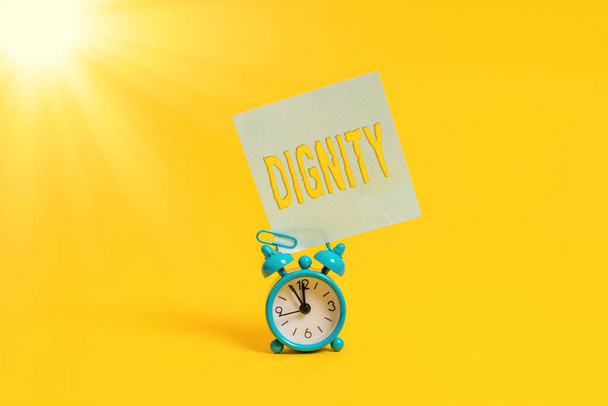 Word writing text Dignity. Business concept for Quality Being worthy of honor respect Serious manner style Metal retro vintage alarm clock blank sticky note sheet colored background. - Photo, Image